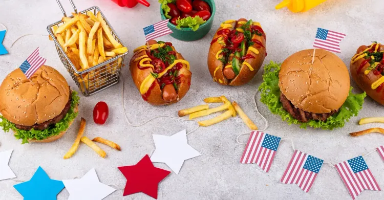 Fourth of July spread with burgers, hot dogs, fries, condiments, and American flags celebrating foodservice in America.