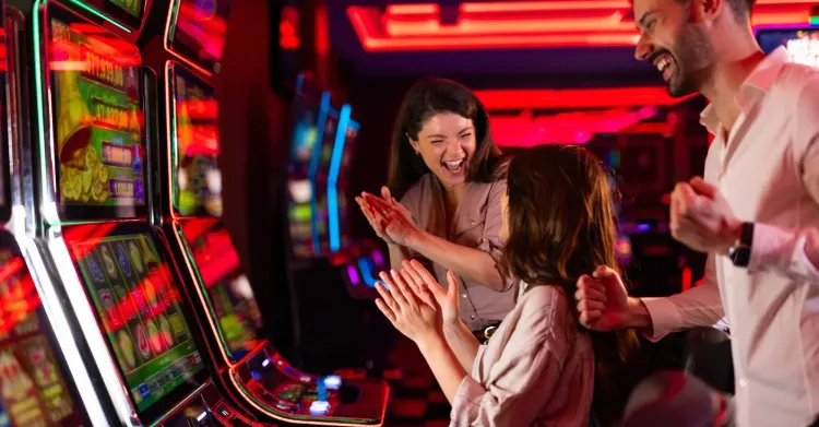 Casino guests celebrating at slot machines, representing strong slot performance and the importance of reliable gaming technology.