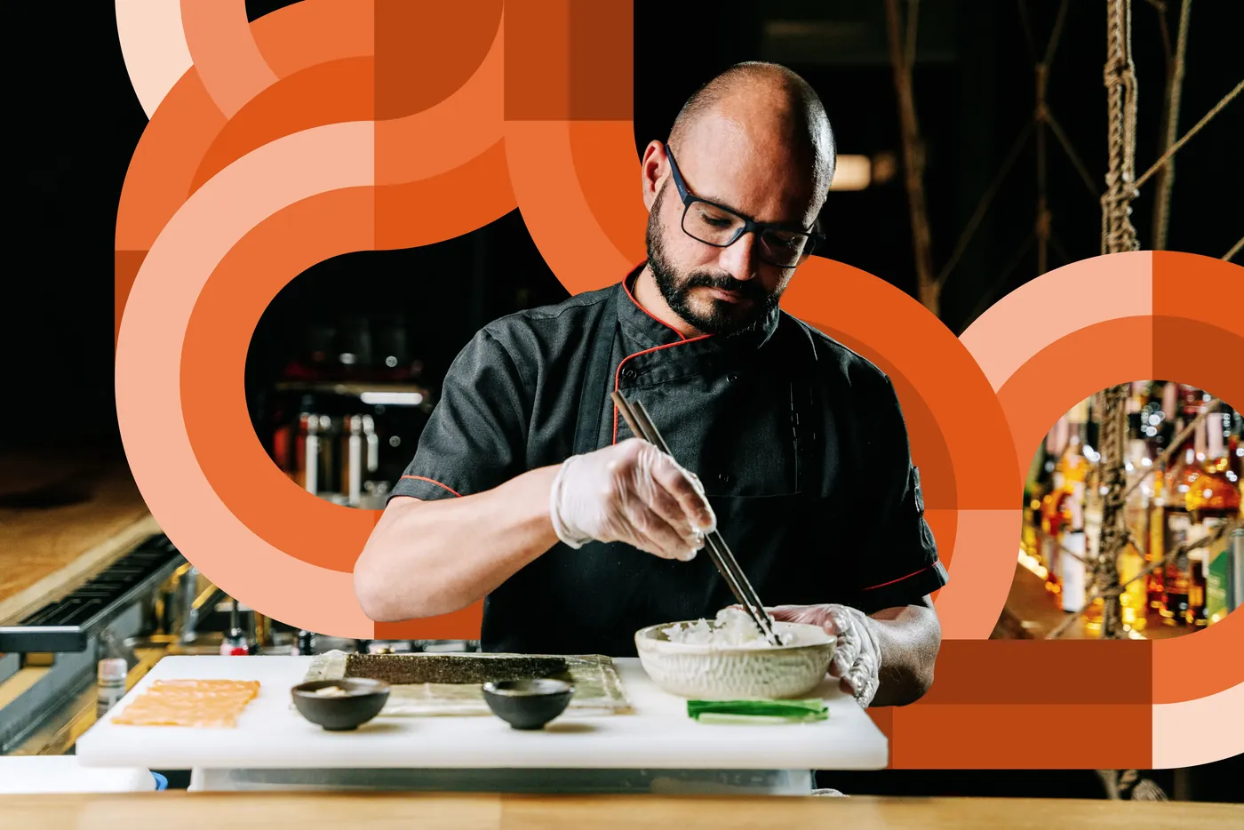 A chef plating a dish at a kitchen pass amid orange circular brand graphics