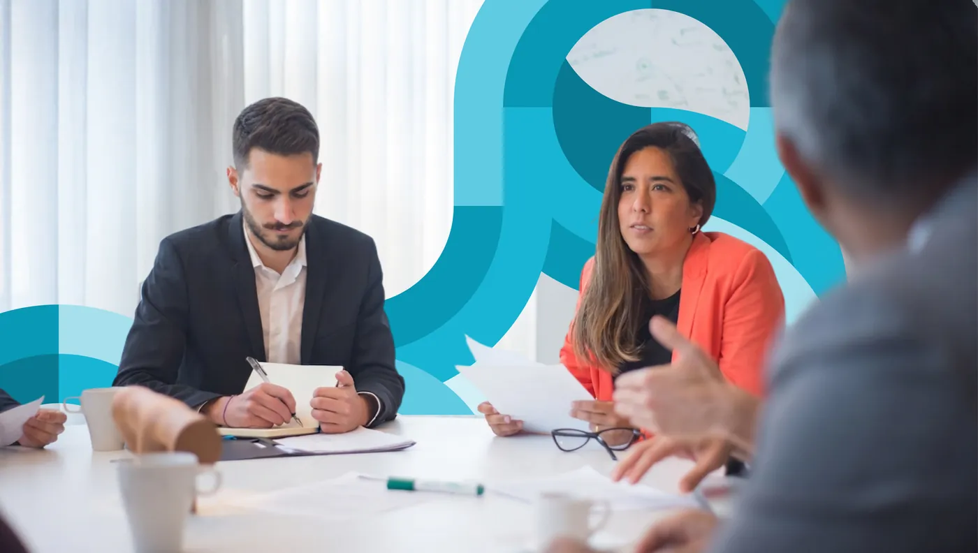 A corporate team reviewing documents together at a meeting table amid teal circular brand graphics