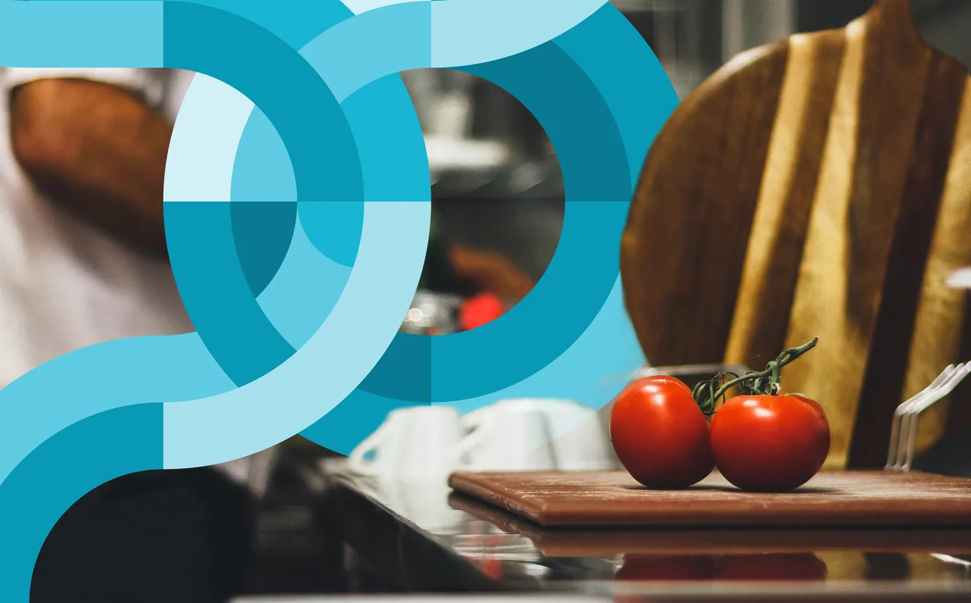 Fresh tomatoes and cutting boards on a kitchen counter amid teal circular brand graphics