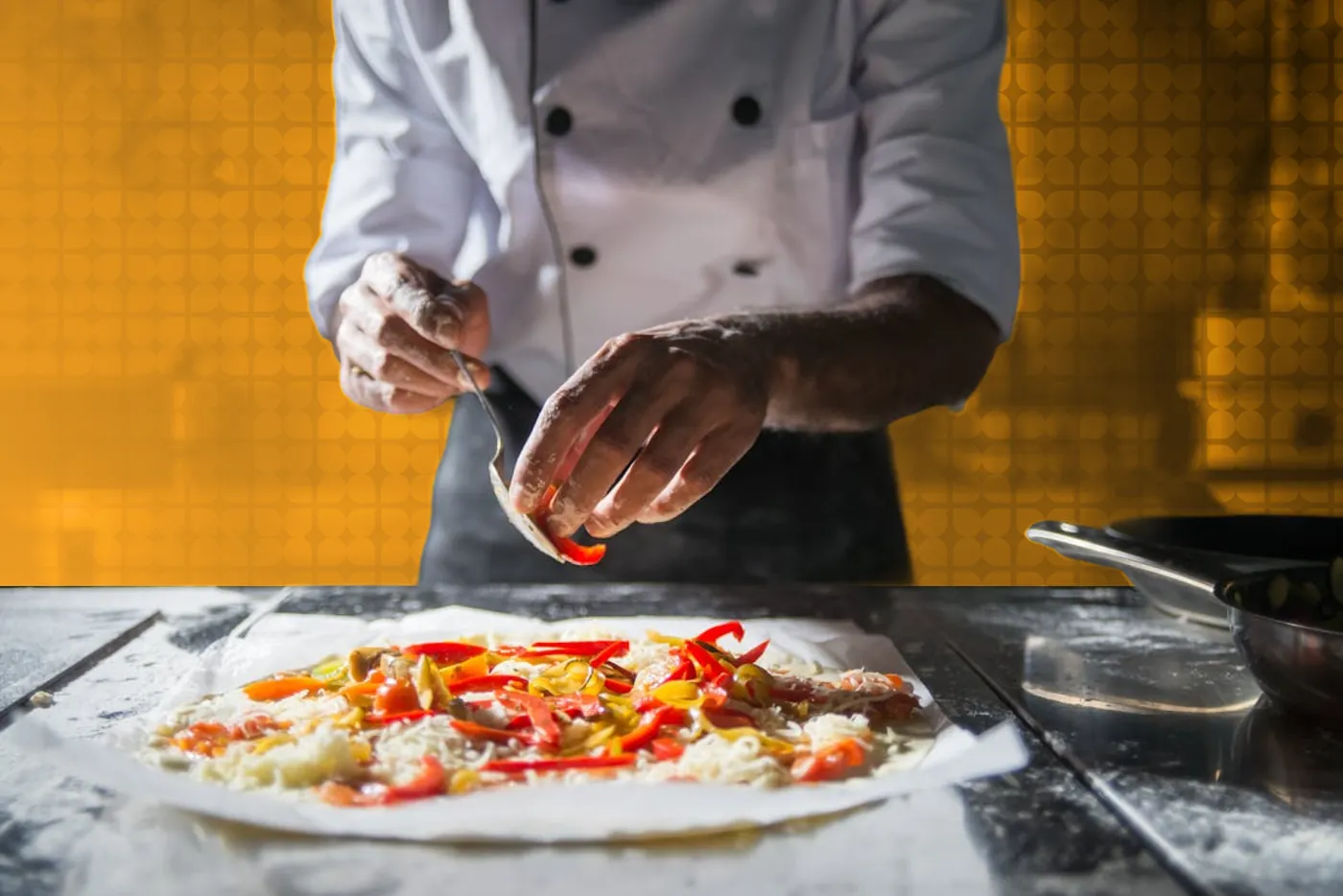 A chef plating a dish over a bed of fresh ingredients, in black and white