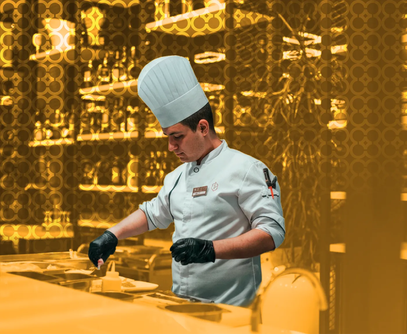 A chef in a toque working at a bar counter, in amber duotone