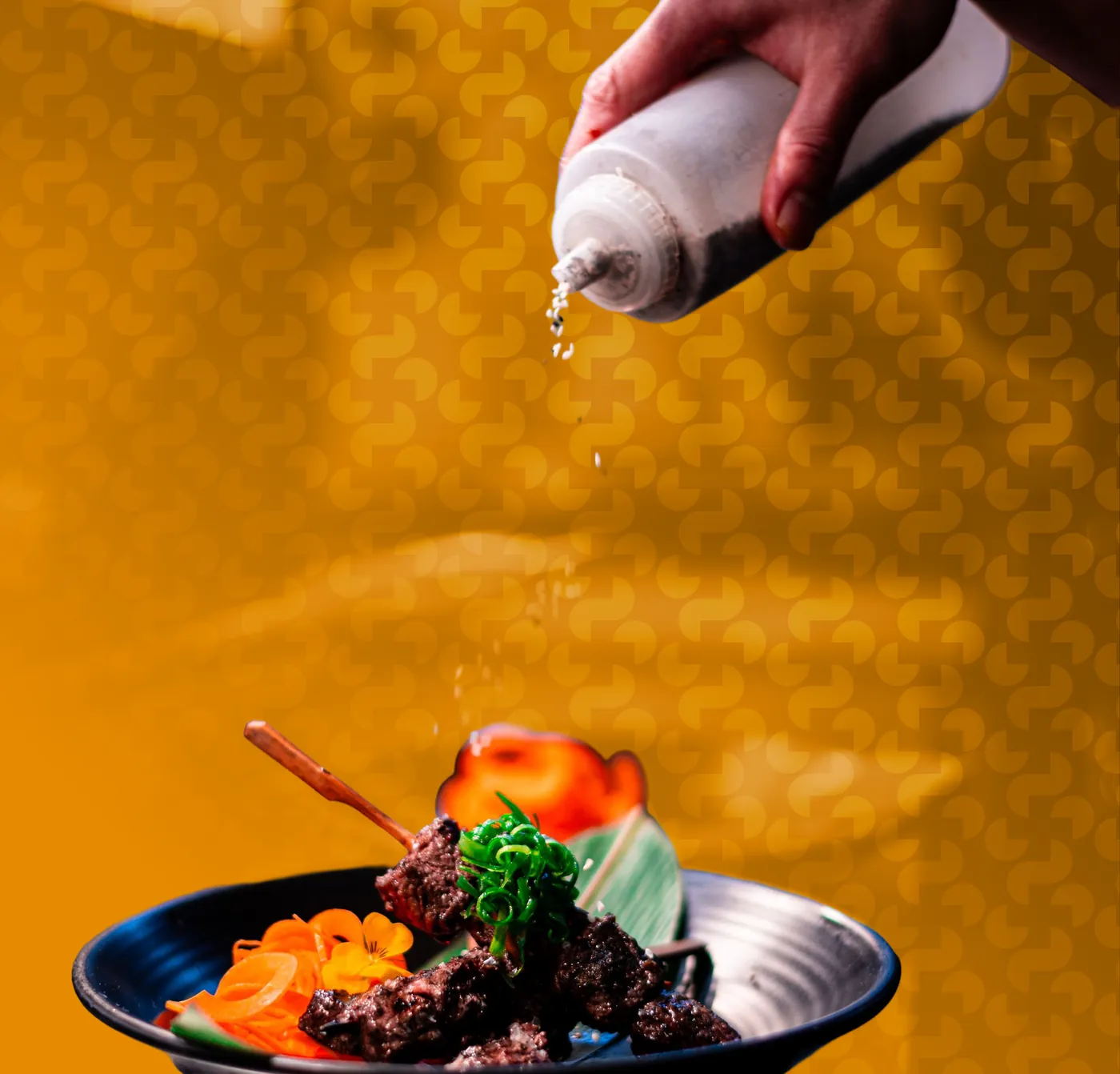 A chef finishing a plated dish, in orange duotone