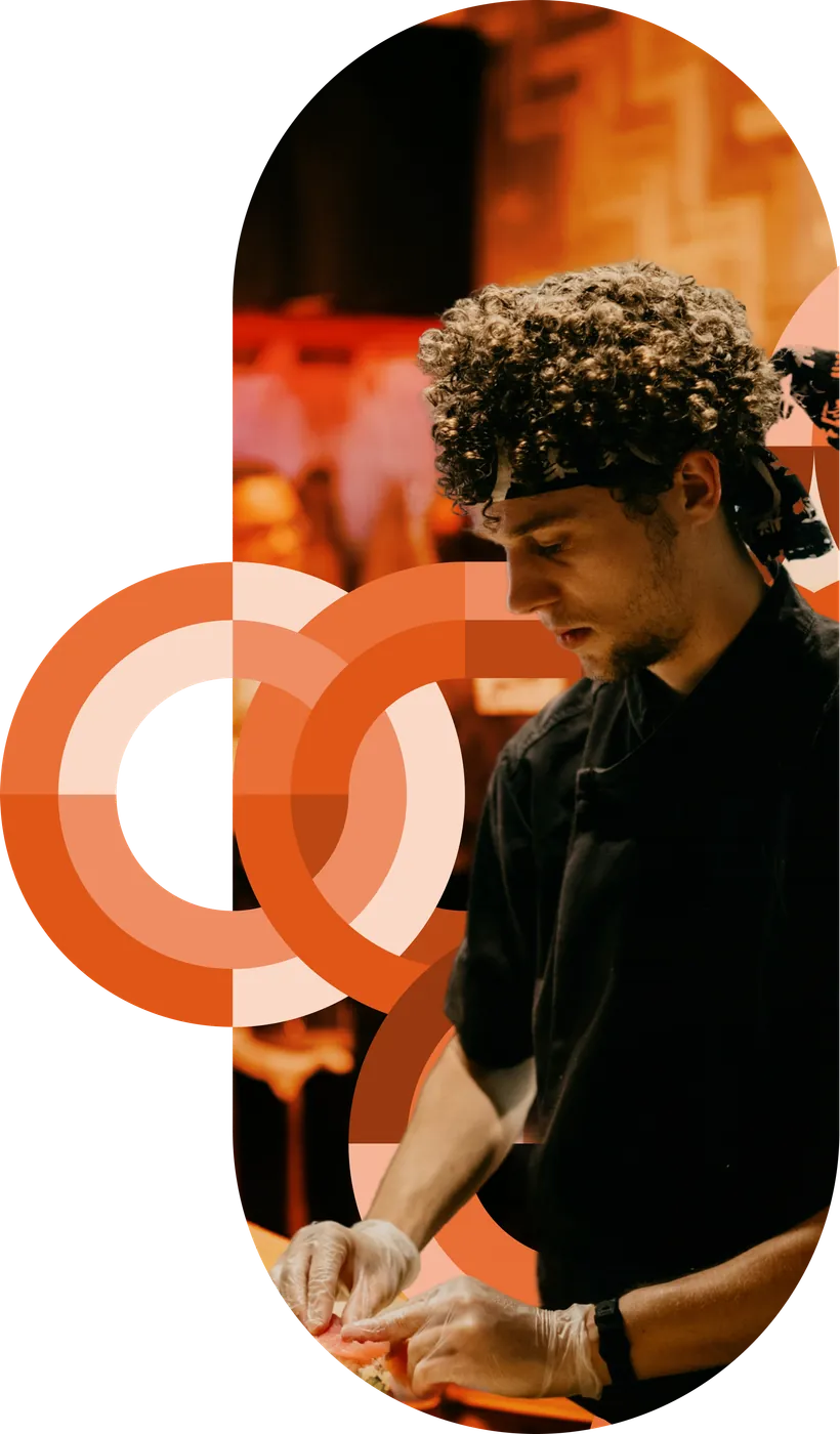 A sushi chef preparing food amid orange circular brand graphics