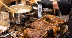 Foodservice worker checking the internal temperature of cooked meat with a digital probe thermometer and building an HACCP record with BOHA! Temp.