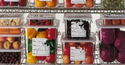 Food storage containers with partially torn labels and adhesive residue, showing the difficulty of removing traditional food prep labels in a kitchen.